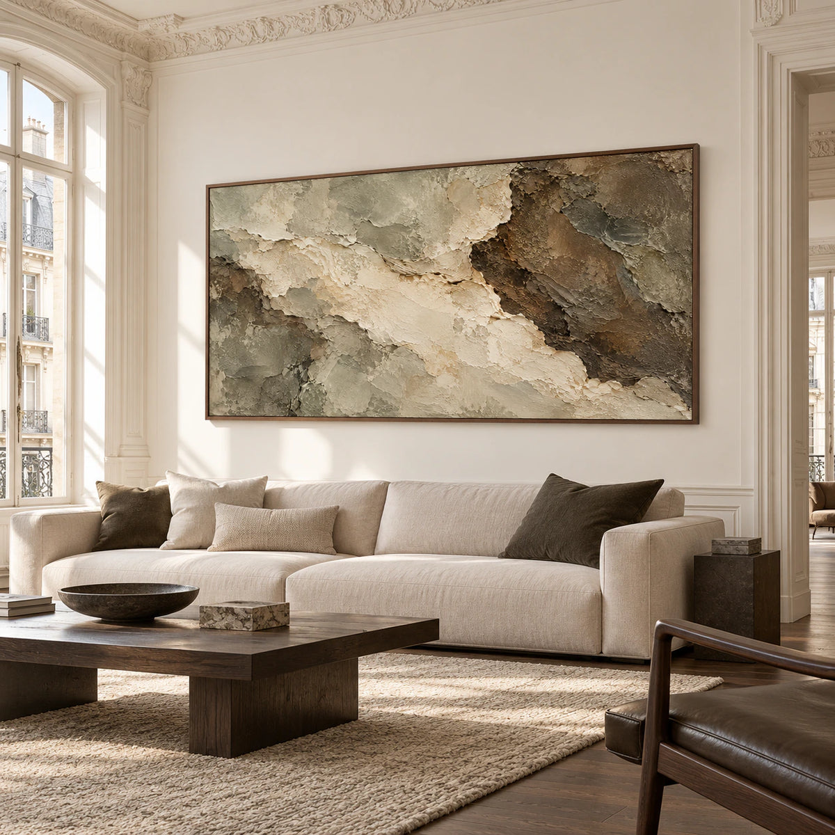 Right-oblique view of a wide textured abstract painting on a warm-white wall in an ornate sitting room with broad windows and natural daylight.