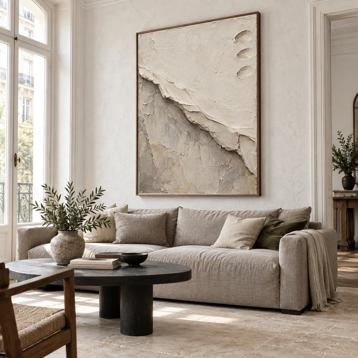 Vertical textured abstract painting above a sofa in a bright living room.