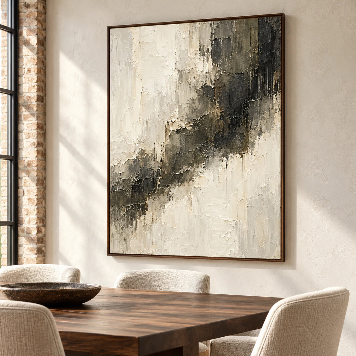 Ivory and charcoal abstract painting in a bright dining room with a dark walnut table, light upholstered chairs and pale walls, viewed from the right at seated height.