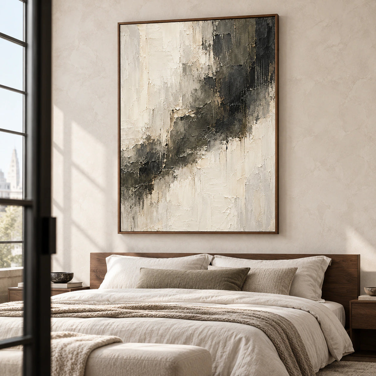 Large ivory and charcoal abstract painting above a bed with pale linen bedding and a muted wood headboard, viewed from a slightly elevated left angle.