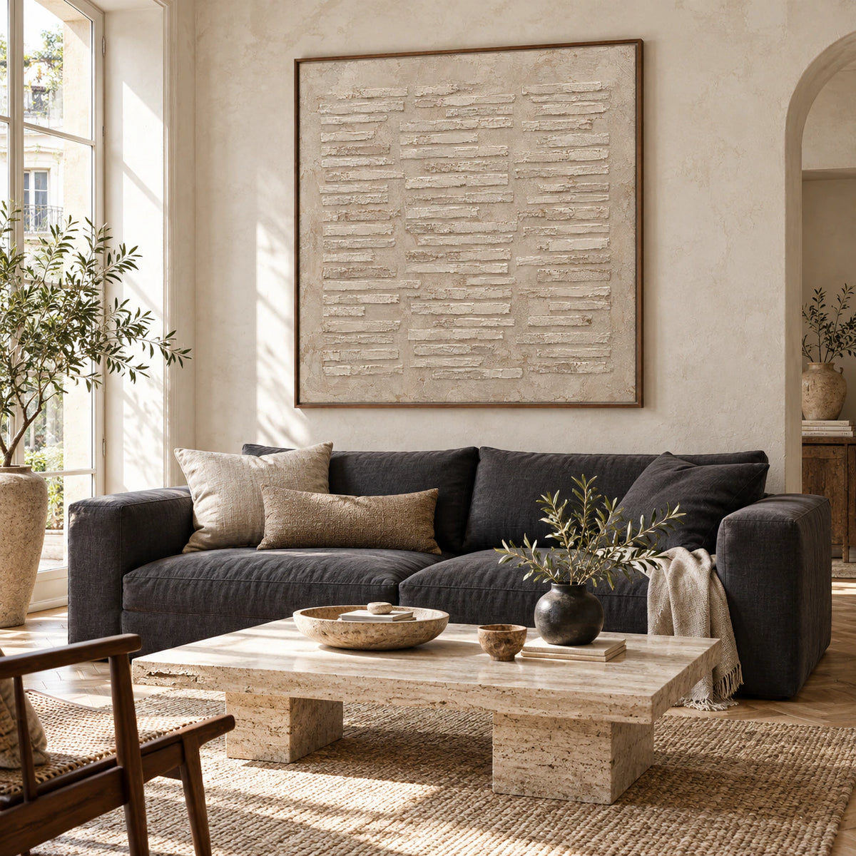 Square chalk-white relief painting above a restrained sofa in a bright contemporary living room.