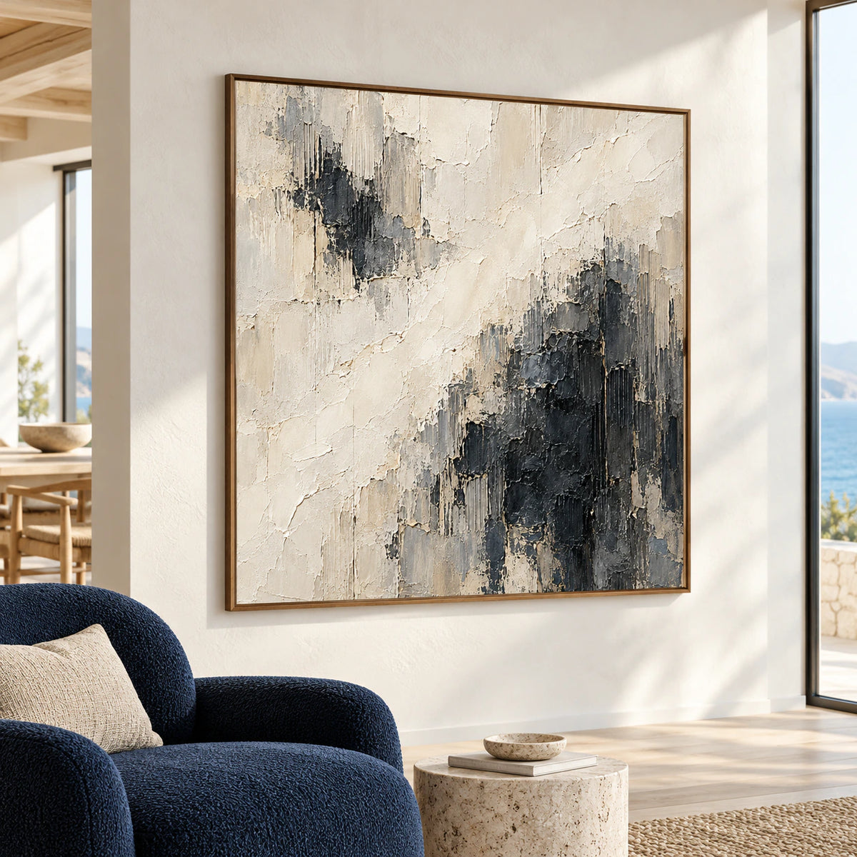 Standing-height right-oblique view of Cinder-Ledger on a warm-white hospitality loft wall, with high ceilings, a large window, navy lounge chair, and stone side table.