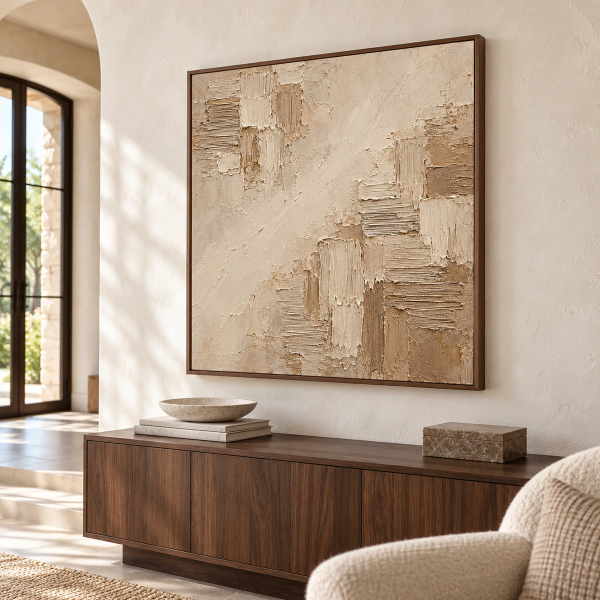 Square abstract artwork at large scale on a pale foyer wall, with a generous entry and restrained dark wood furnishings in natural daylight.