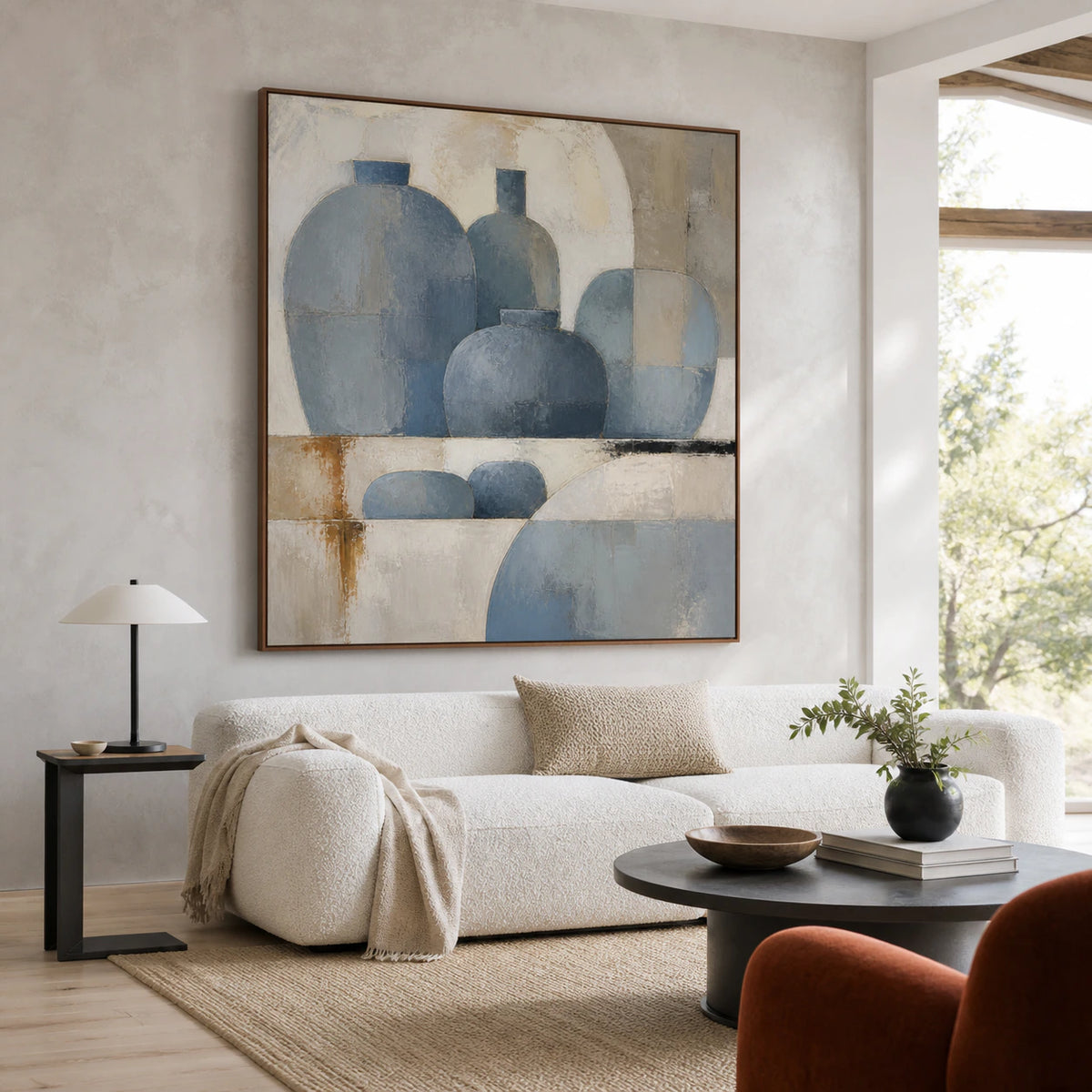 Square blue-grey geometric painting above a sofa in a bright living room.