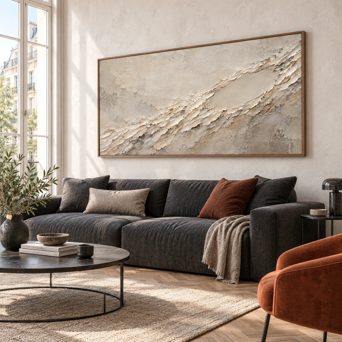 Textured ivory and gray abstract artwork above a sofa in a bright living room.