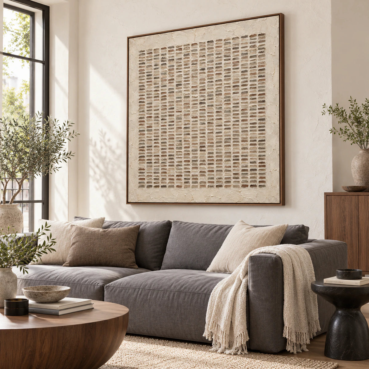 Earthen-Register square textured abstract painting above seating in a bright living room.