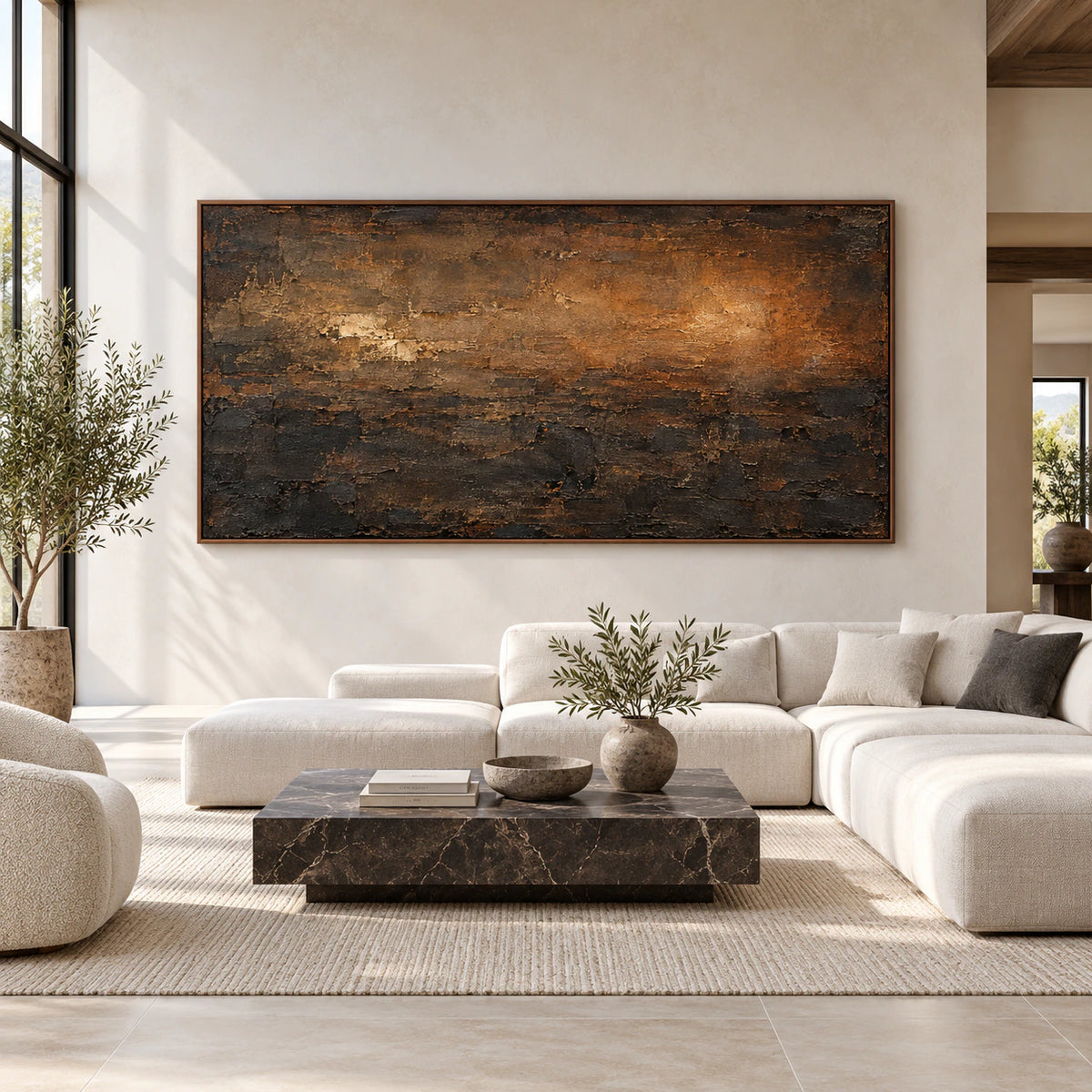 Wide brown and ochre abstract painting in a slim frame, viewed straight on in a bright, spacious room with pale stone, ivory and dark wood furnishings.