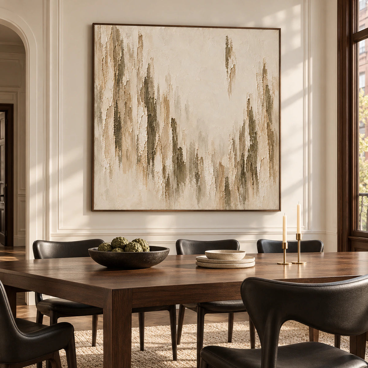 Square textured artwork displayed prominently in a refined dining room with a long dark wood table and pale stone walls.