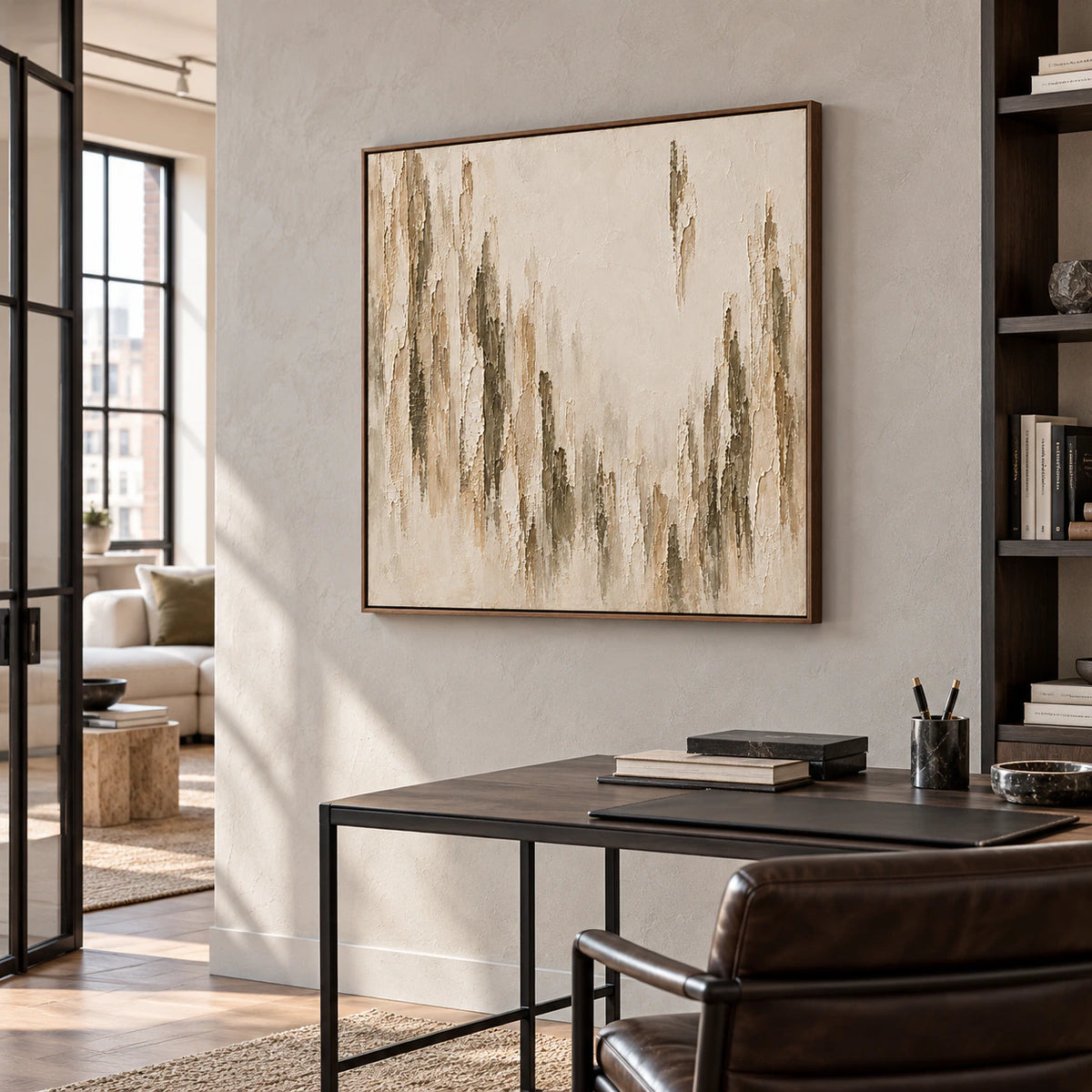 Large square artwork on a light plaster wall in an airy home office with a slim desk, black chair, and natural daylight.