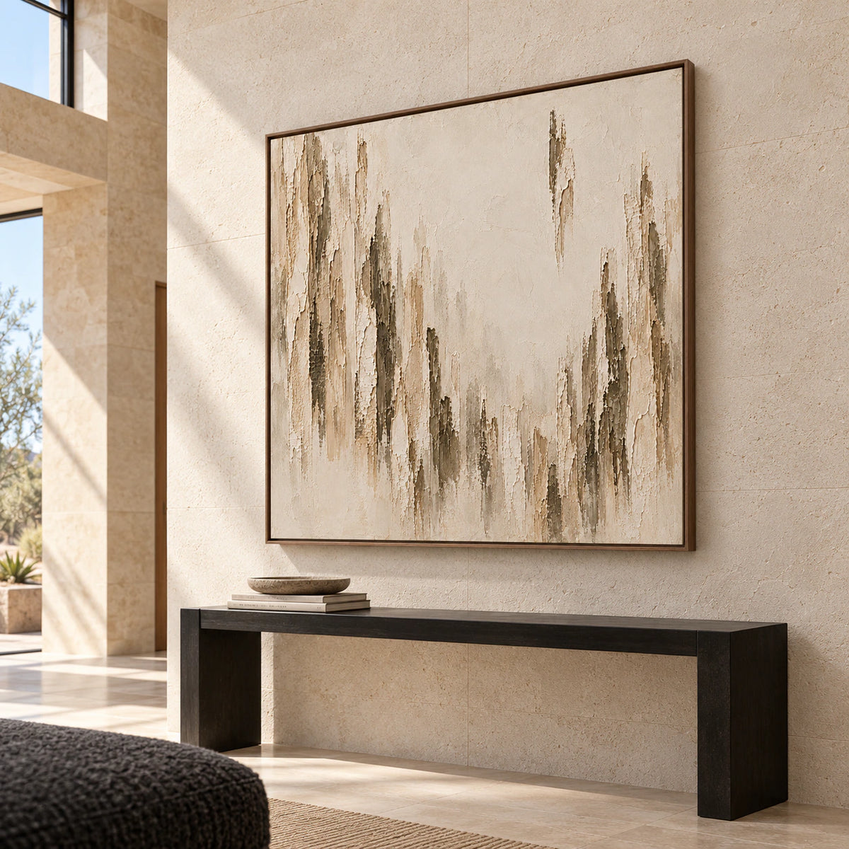 Square artwork commanding a gallery-scale foyer with limestone walls, a dark console, and open daylight from a tall side window.