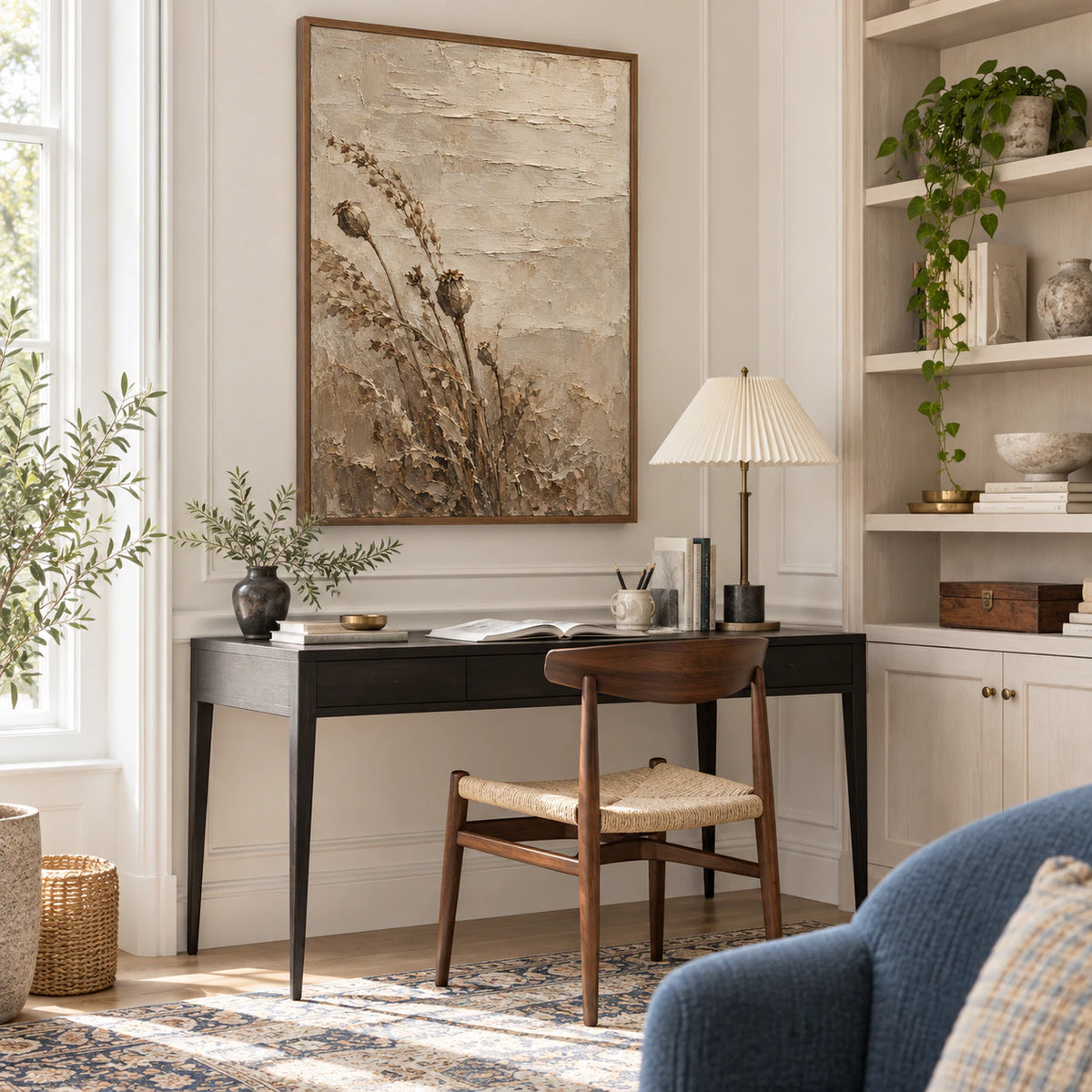 Vertical botanical relief artwork in an airy reading and home office space.