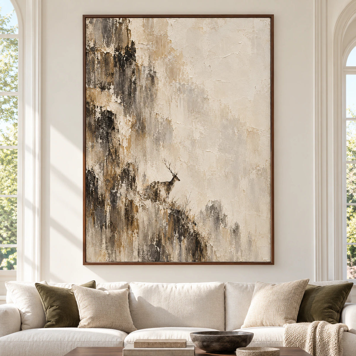 Large vertical artwork centered in a spacious, bright room, showing a solitary stag among dark weathered woodland forms against warm ivory and sand.