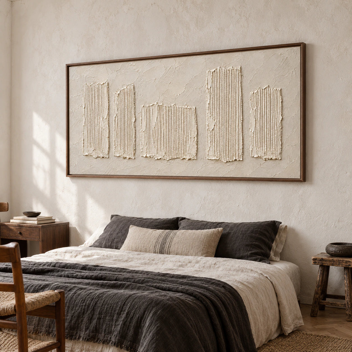 Wide ivory relief artwork above a low bed in a quiet, daylight-filled bedroom.