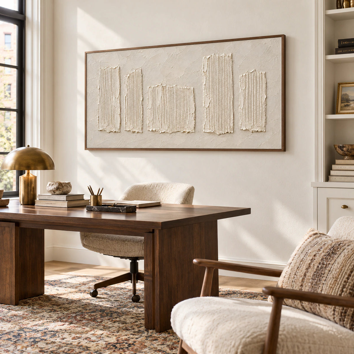 Sculptural ivory artwork displayed prominently in an airy home office with a simple desk and reading chair.