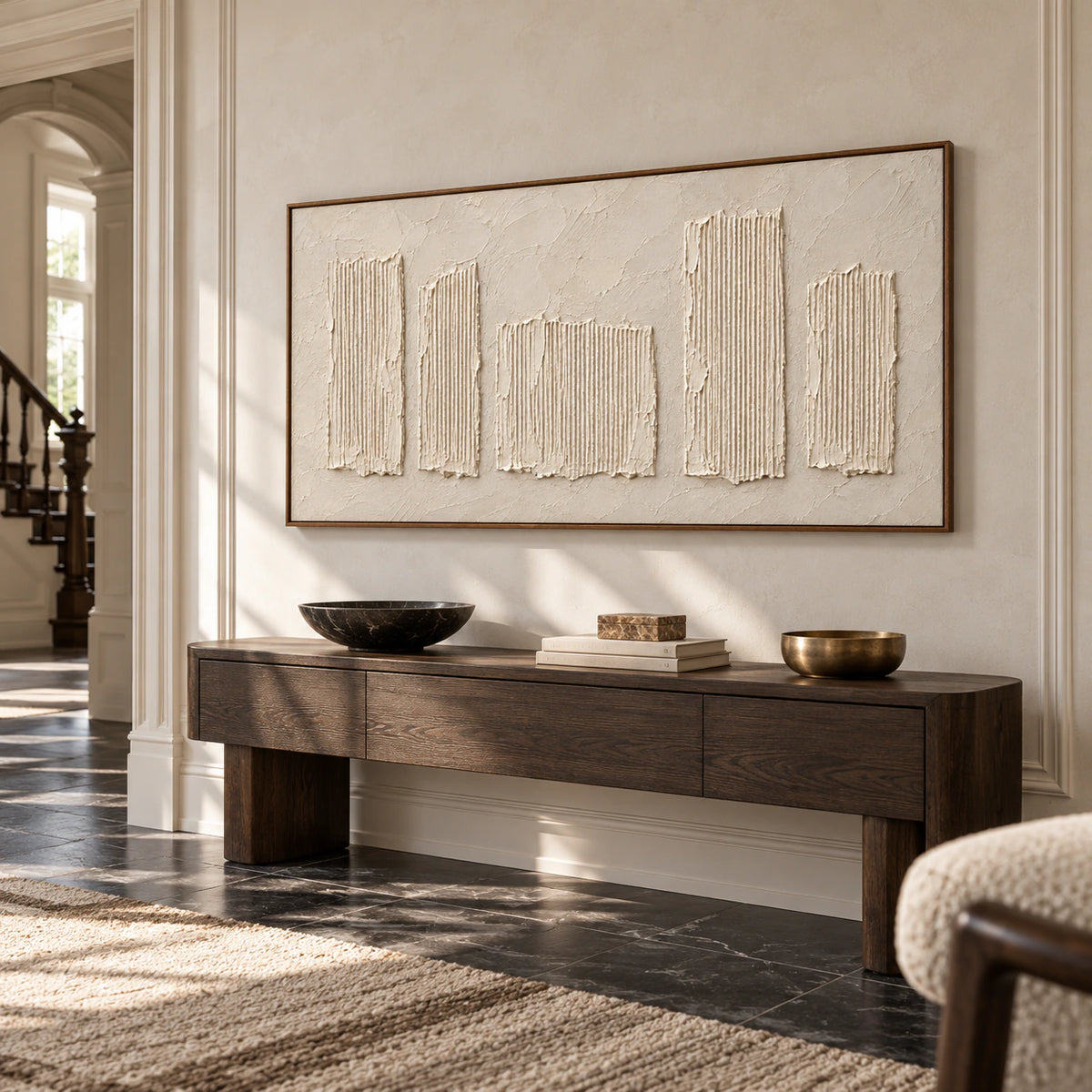 Large horizontal ivory artwork commanding a bright gallery-scale foyer with stone flooring.