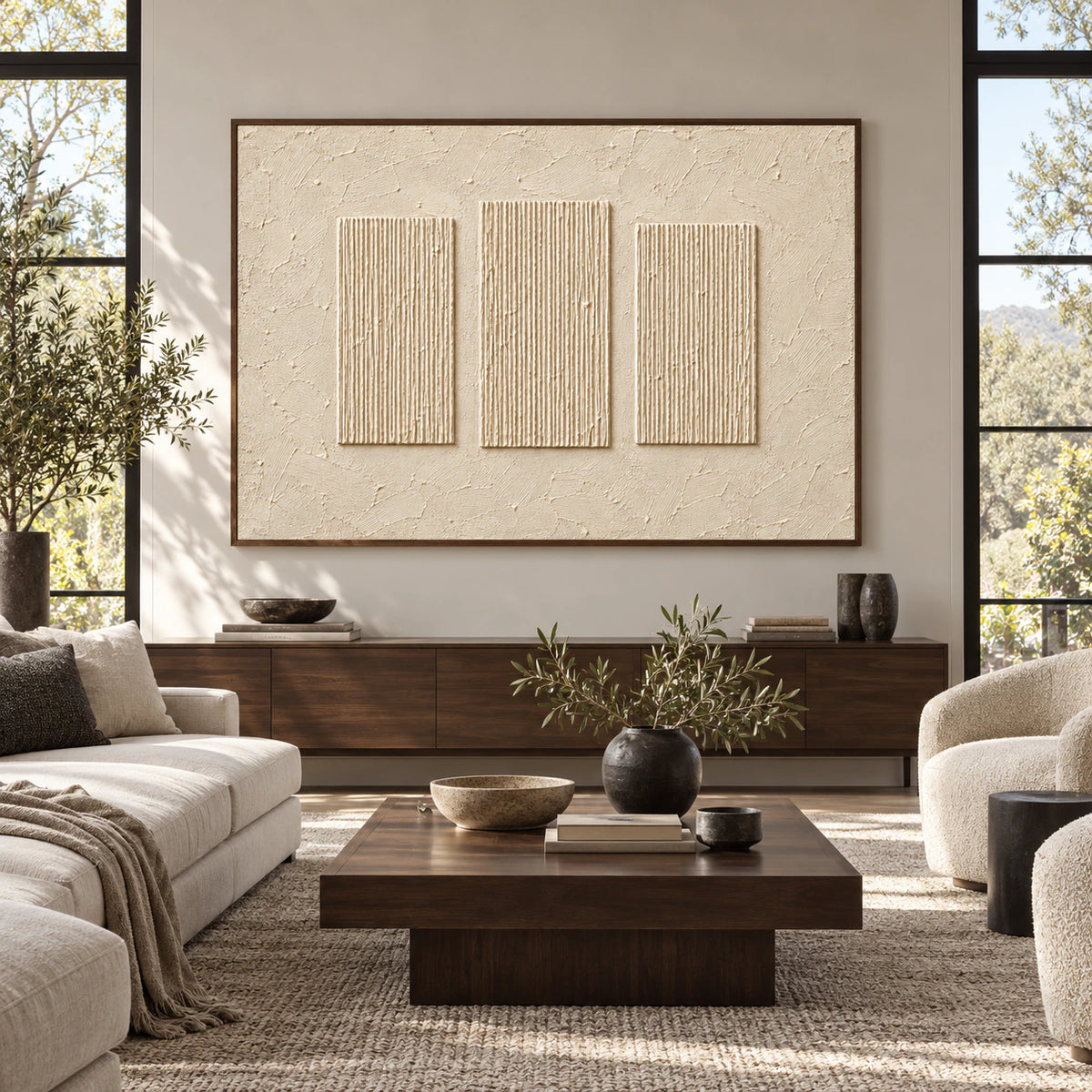 Ivory artwork with three ribbed rectangles centered on a wall, viewed straight-on in a spacious, daylit room with charcoal, pale stone and dark wood furnishings.