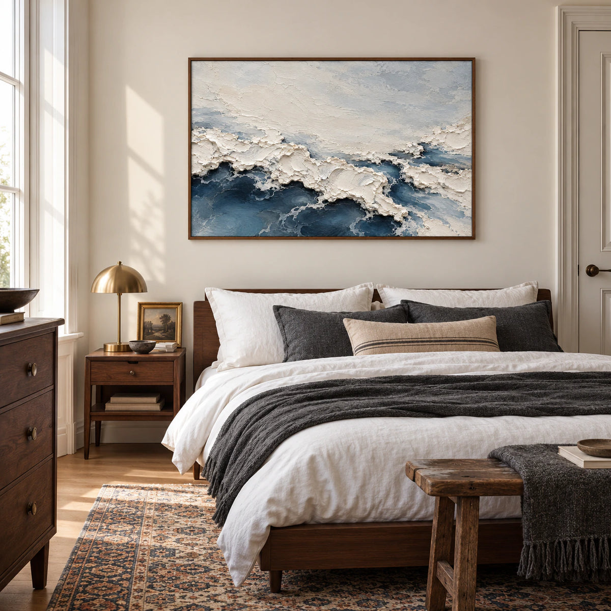 Foam Traverse hangs above a quiet bedroom's low walnut bed, its raised ivory and slate-blue forms prominent in soft daylight.