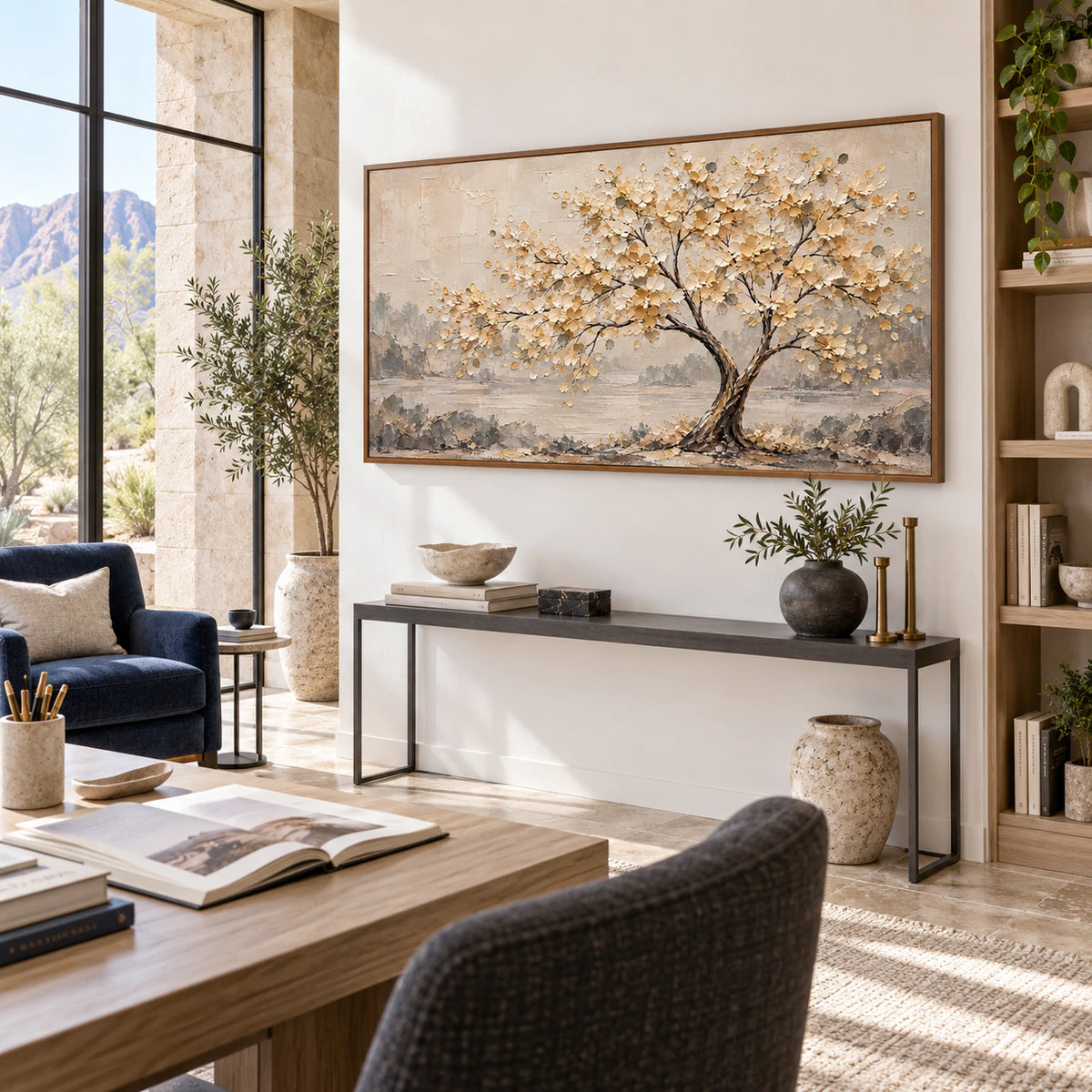 Large Gilded-Bough painting in an airy home office reading space with daylight and open shelving.