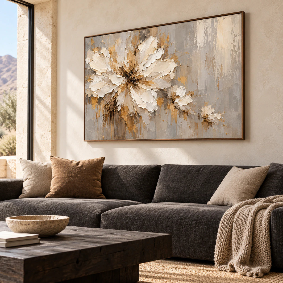 Ivory floral abstract painting as the focal point above a restrained charcoal sofa in a bright living room.