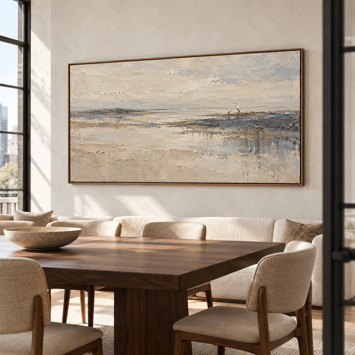 Textured heron landscape above a long dark wood dining table against a pale plaster wall in a sunlit dining room, viewed from the right at seated eye height.