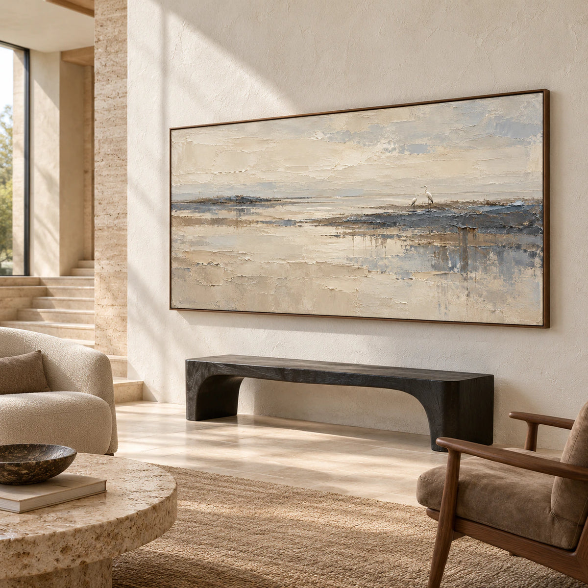 Large heron shoreline painting in a spacious foyer with a limestone floor, sculptural black bench and high window, viewed from the right and slightly below.