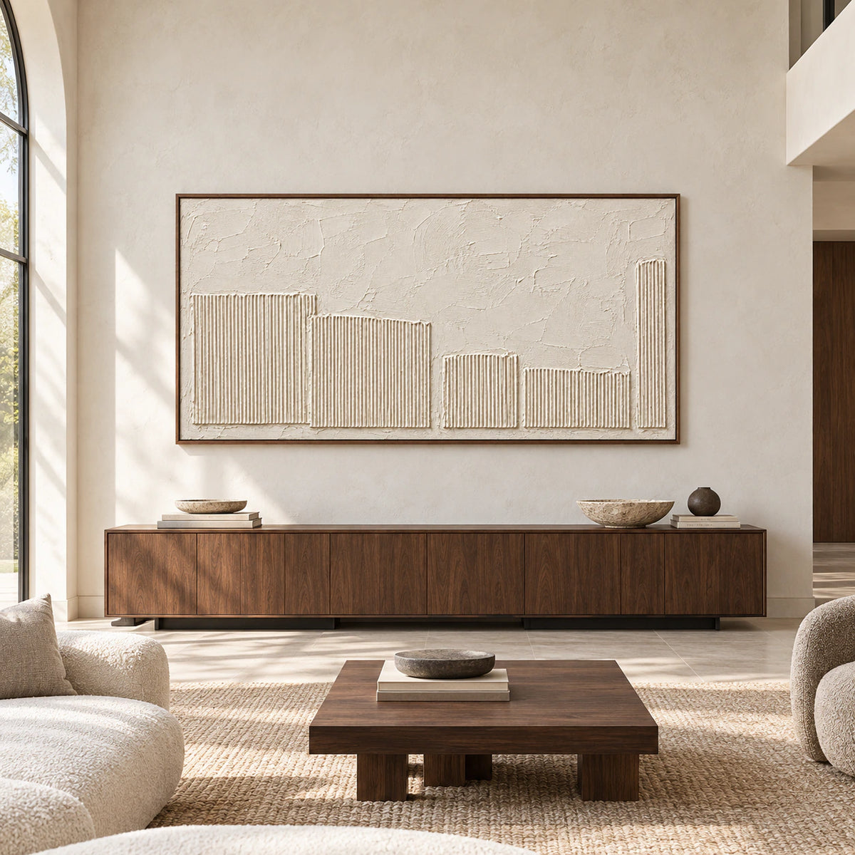 Ivory textured painting viewed straight on above a dark walnut console on a broad pale plaster wall in a spacious, naturally lit interior.