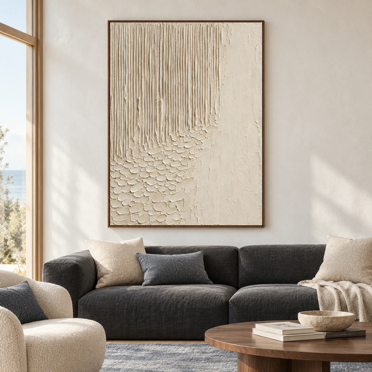 Ivory-Cascade oil painting above a low charcoal sofa, with a dark wood side table and blue-gray rug, viewed from a gentle left angle.