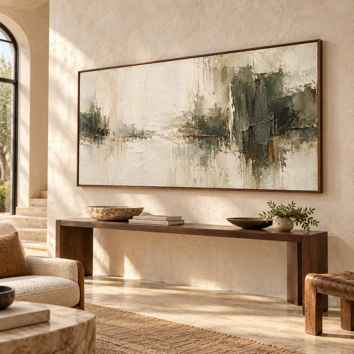 Ivory-Divide on a pale limestone wall in a high-ceilinged foyer with a narrow console and leafy branch, viewed from a low left angle.