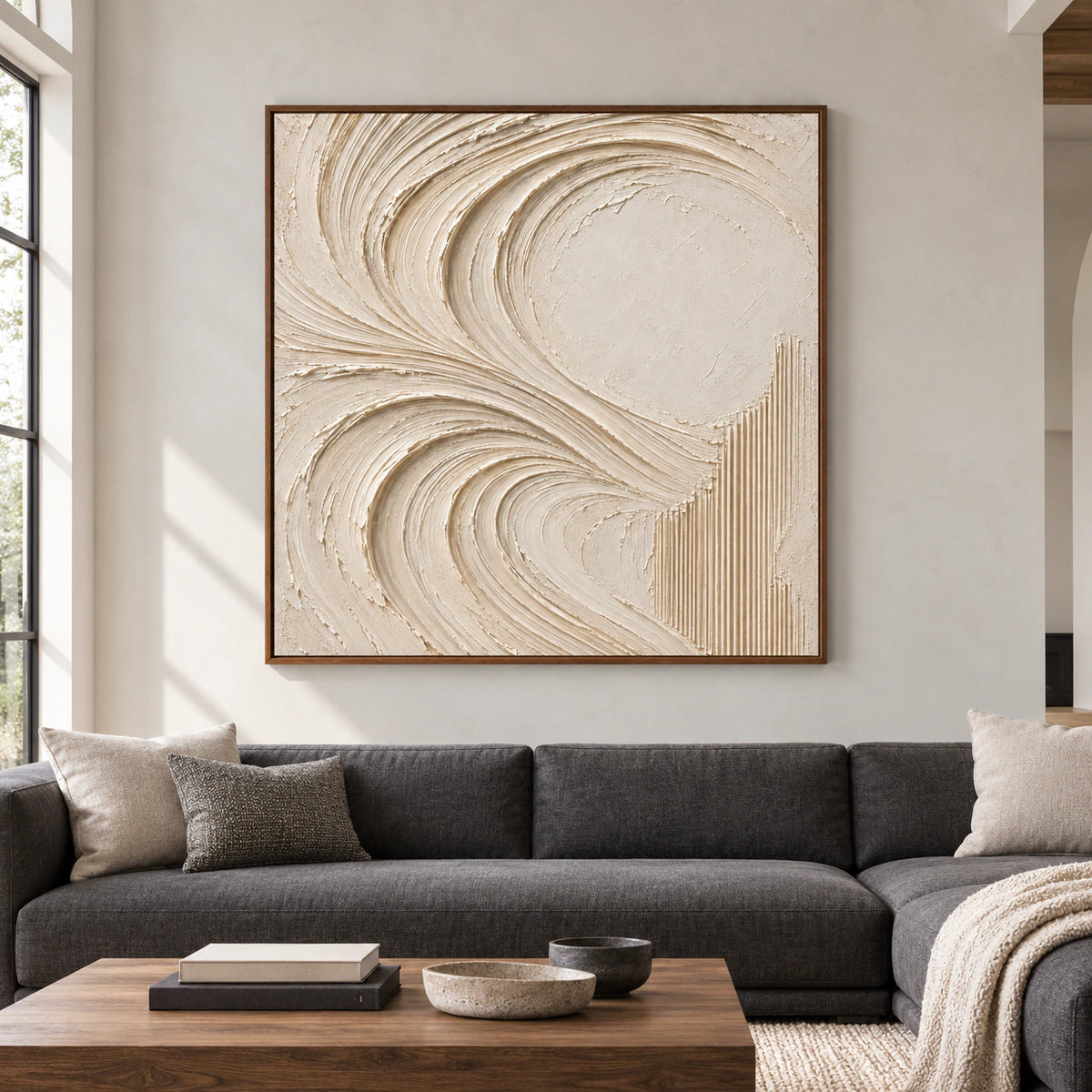 Straight-on view of a large square ivory abstract painting in a spacious, daylit room with charcoal, pale stone and natural wood furnishings.