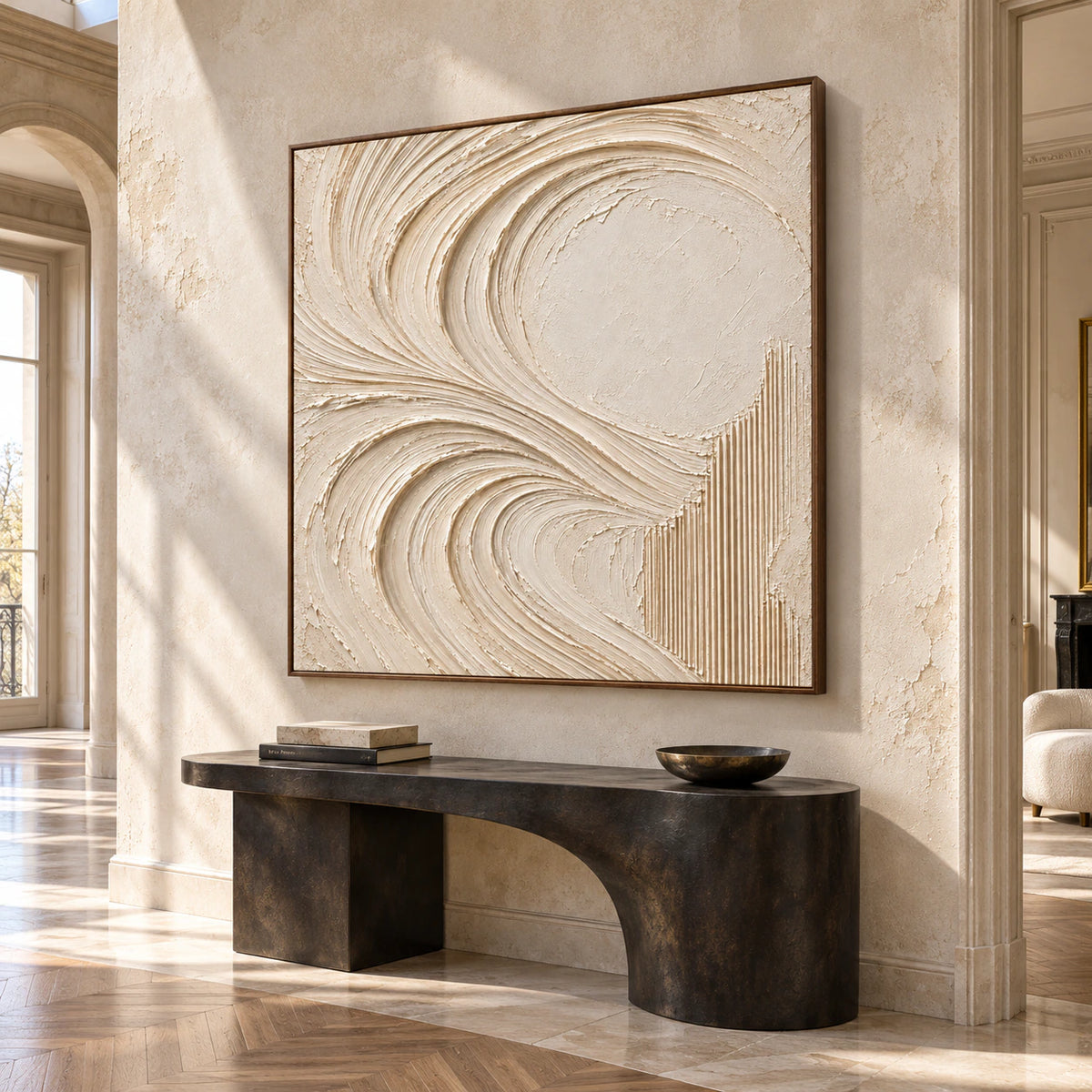 Large square ivory abstract painting on a tall pale limestone foyer wall, viewed from an elevated left angle, with a dark sculptural console table and polished stone floor.