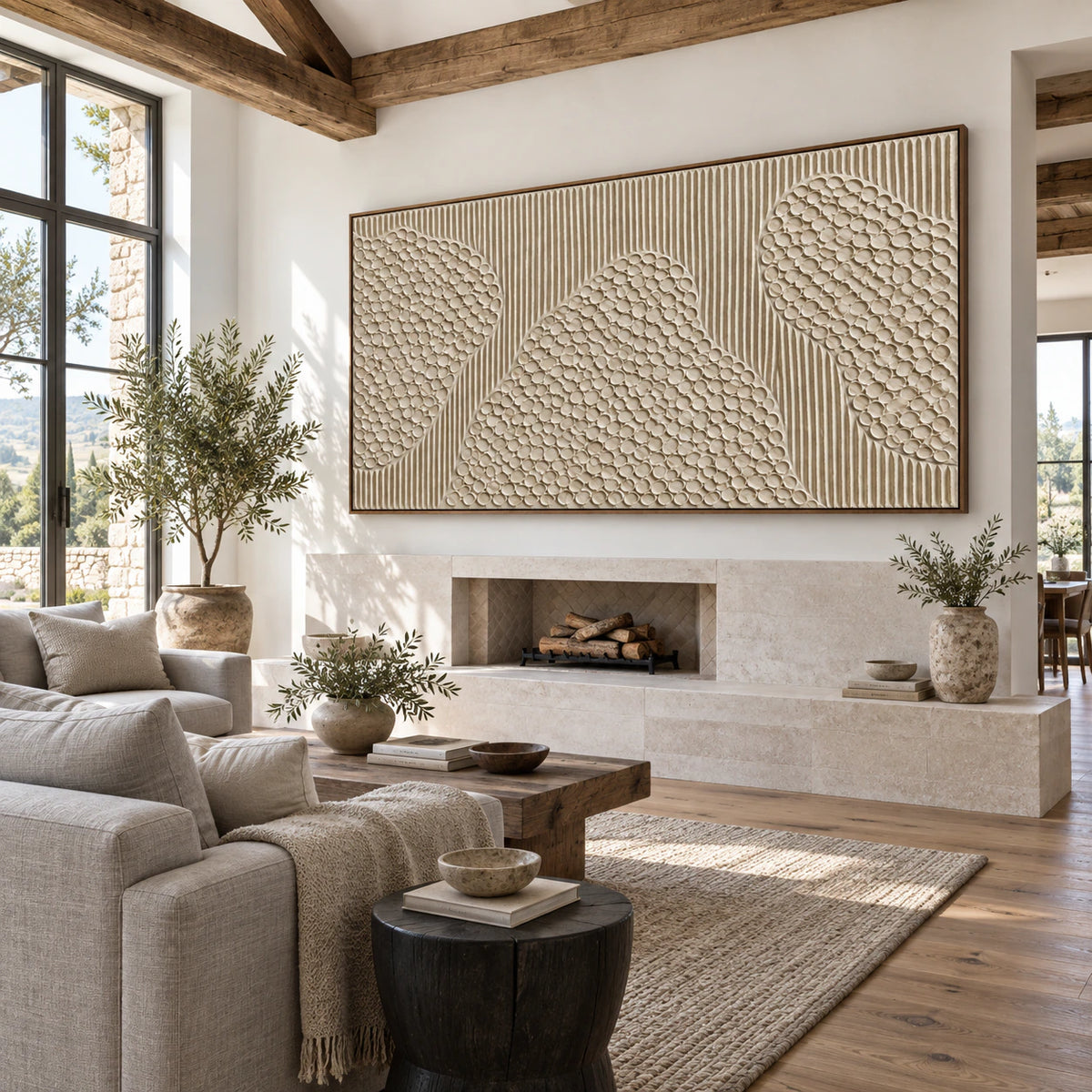 Off-white textured abstract painting above a pale stone fireplace in a bright living room.