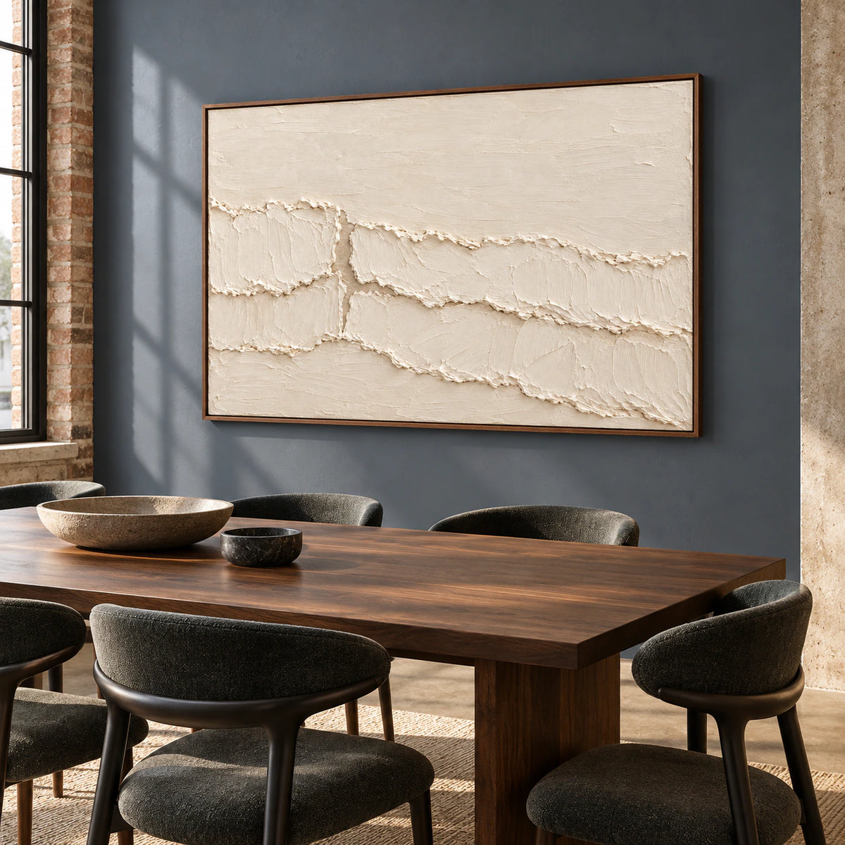 Ivory textured abstract painting anchoring a refined dining room with a dark wood table and pale stone walls.