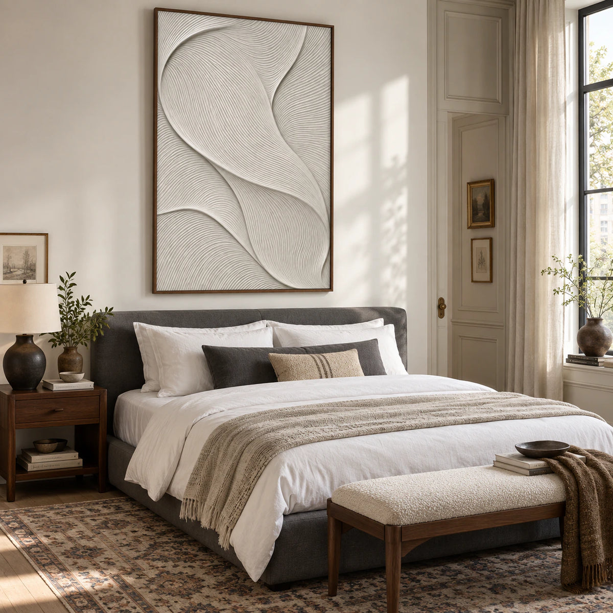 Ivory sculptural linear artwork above a calm, softly lit bedroom setting.
