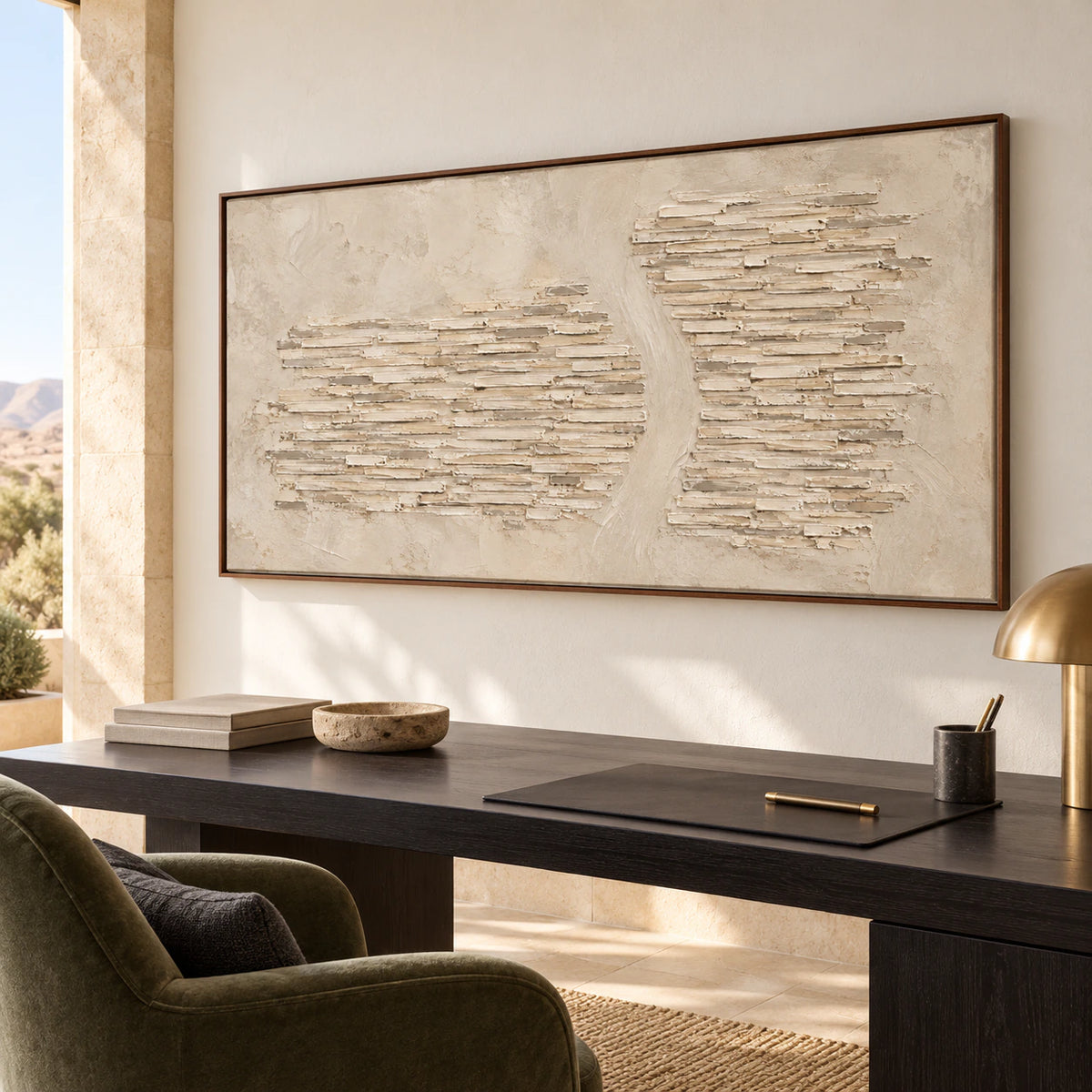 Limestone-Cadence above a black desk with a moss-green reading chair nearby in a bright home office, viewed from the right at desk height.