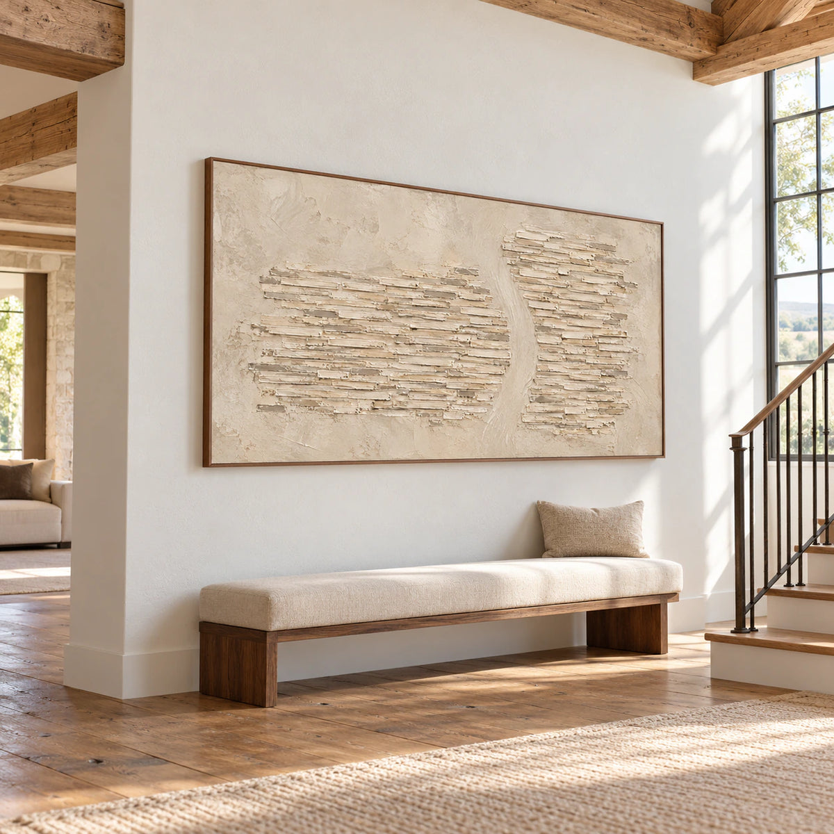 Limestone-Cadence on a tall white foyer wall beside a dark bronze stair rail, viewed from a low left angle with daylight from a high window.