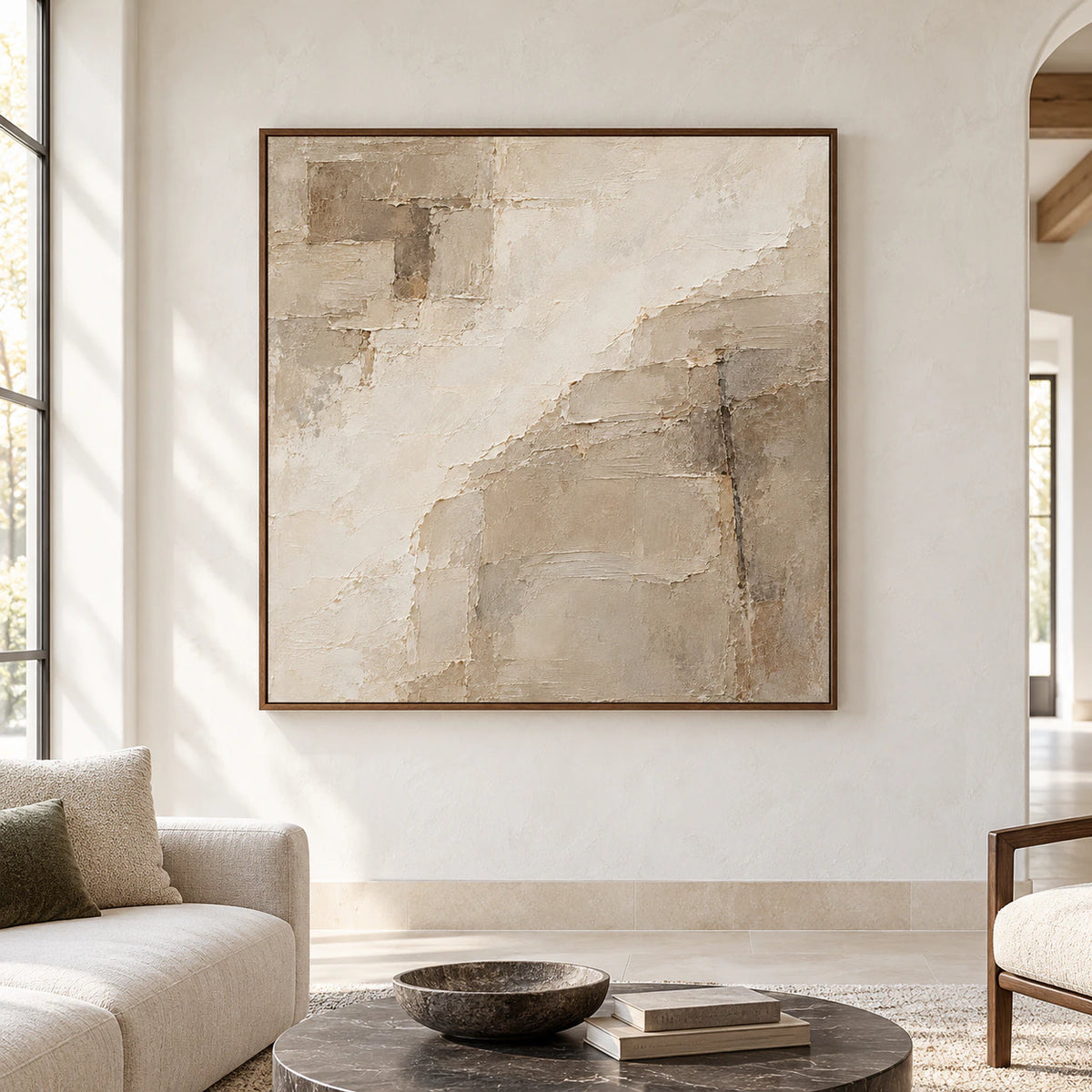Large square abstract artwork in warm ivory and taupe displayed straight-on in an expansive, light-filled room.