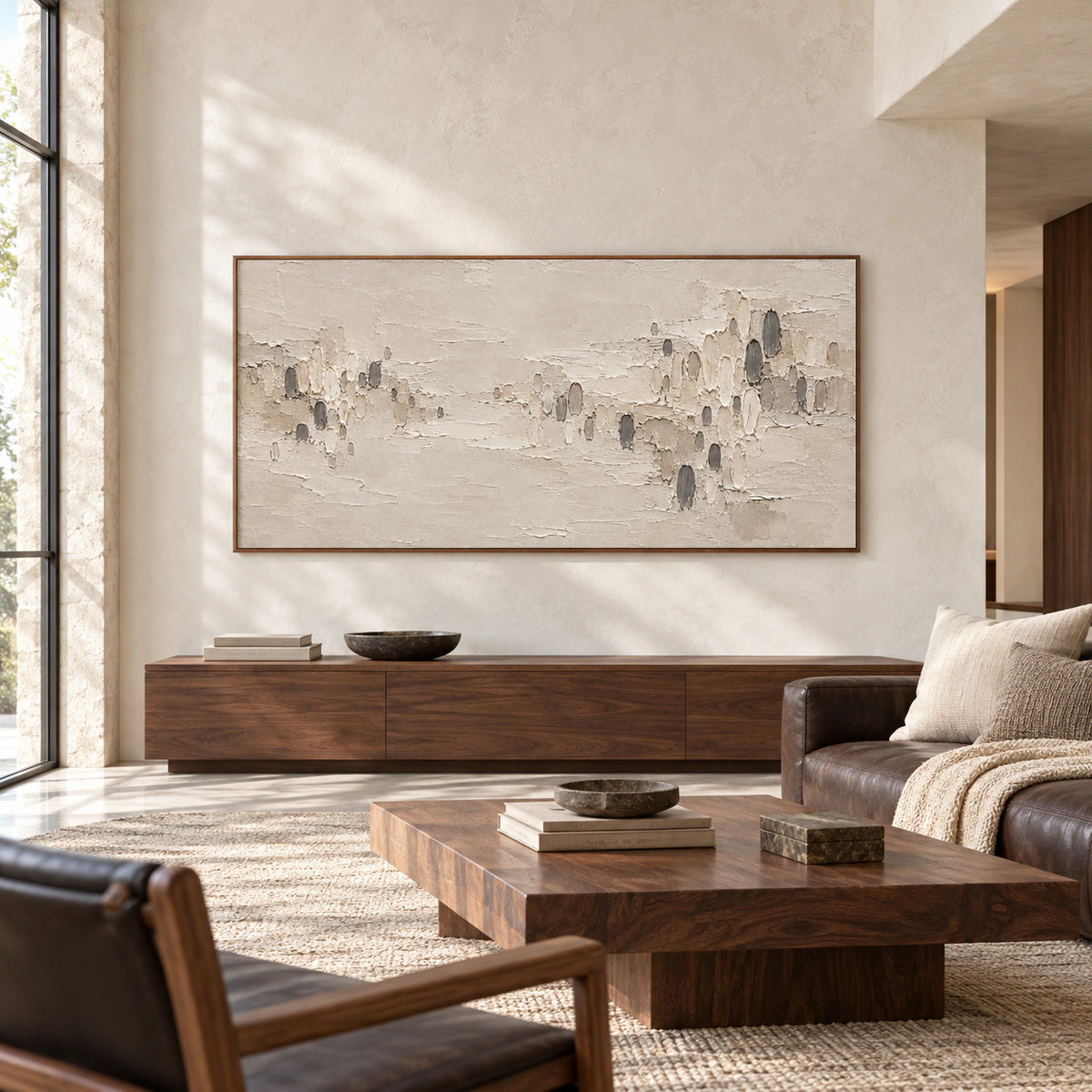 Large horizontal textured abstract painting displayed in an expansive loft interior with pale walls, dark furnishings and broad natural light.