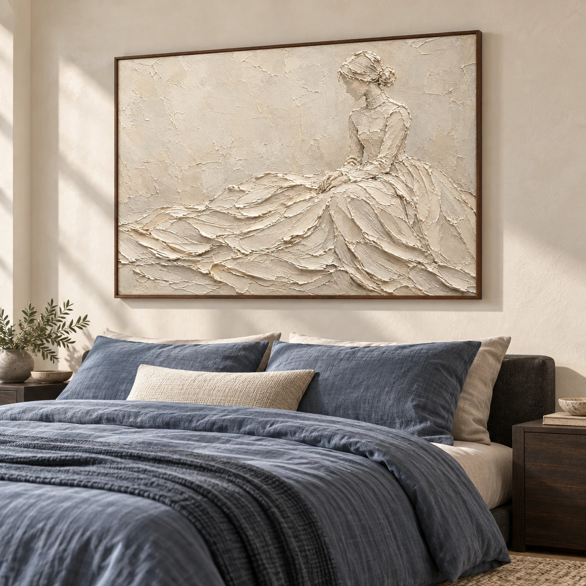 Warm ivory figure painting above a low bed in a quiet, softly lit bedroom.
