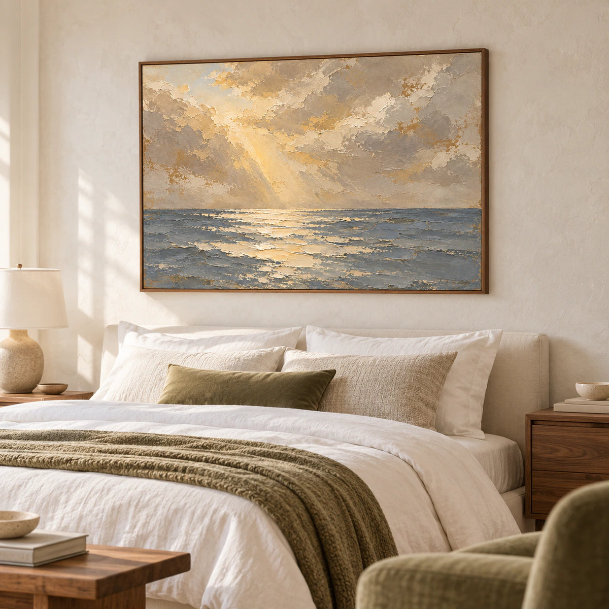 Seascape oil painting above a low bed with white linen, viewed from the left near the foot of the bed, with a muted olive chair and warm wood details.