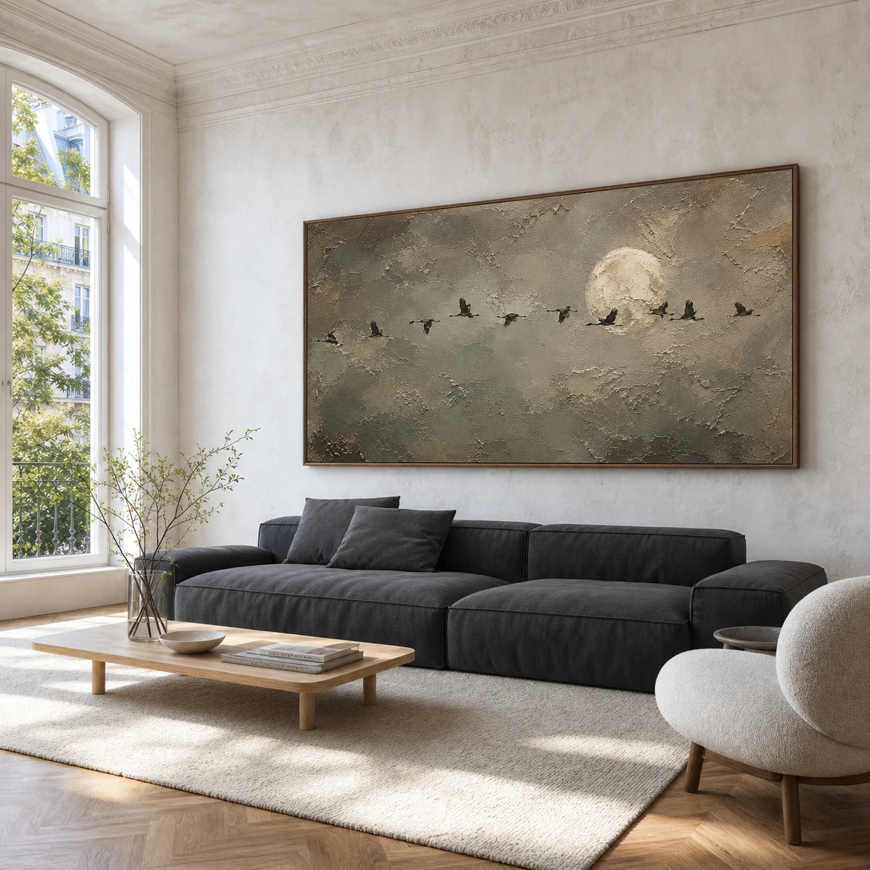 Lunar-Migration displayed above restrained charcoal seating in a bright contemporary living room.