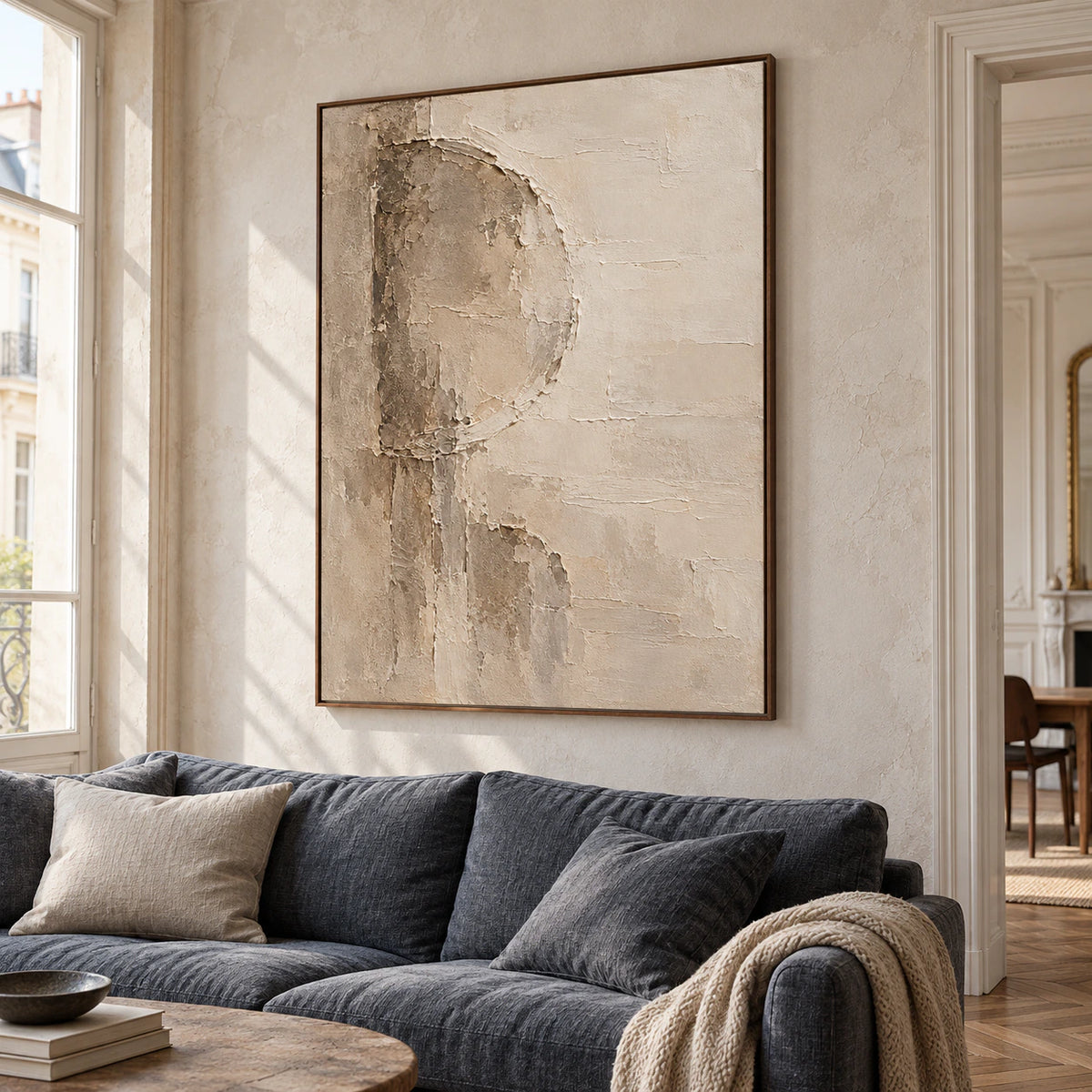 Marl-Aperture painting above a dark sofa in a bright, open living room, viewed from a left-oblique angle in natural daylight.