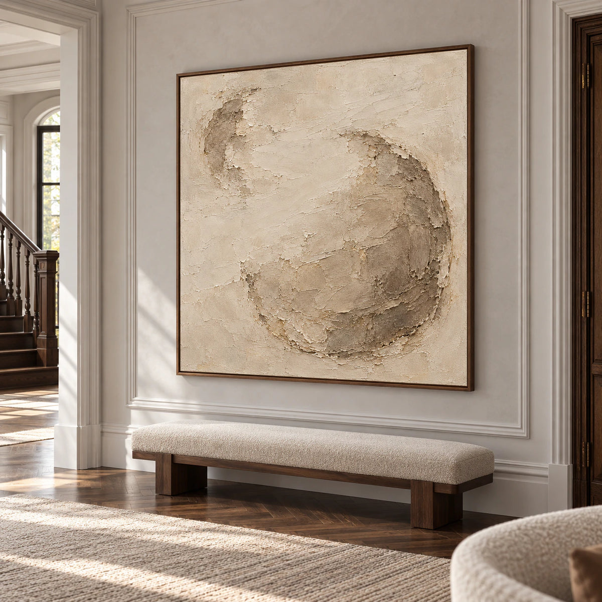 Large square textured artwork in a bright gallery-scale foyer with pale stone walls and open floor space.