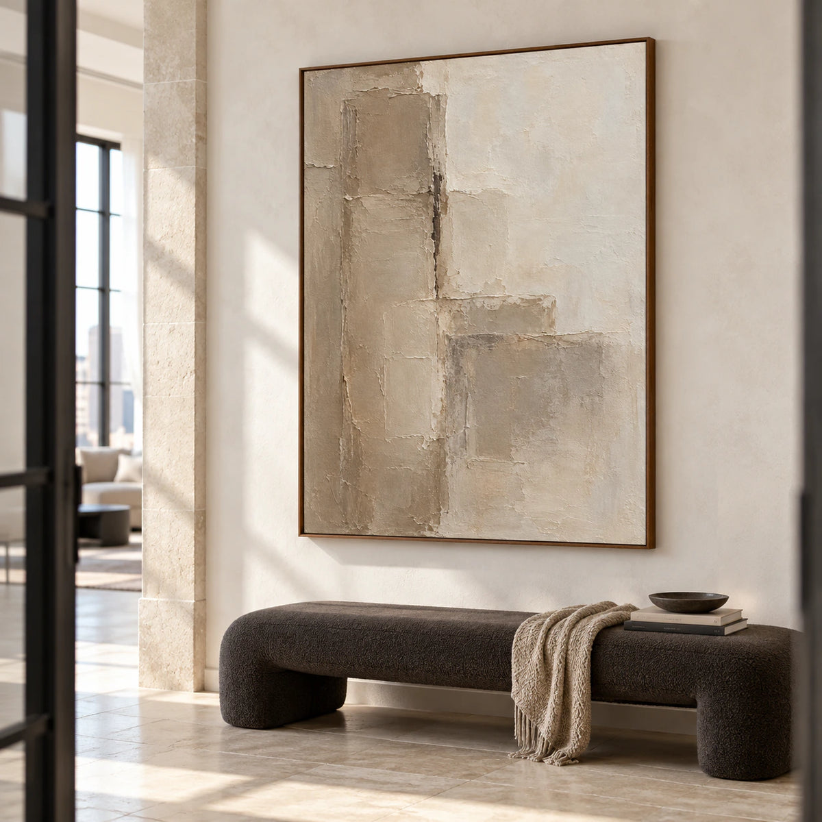 Marl-Tablets in a spacious foyer with pale architectural stone, a sculptural dark bench and open floor space, viewed from the left at a moderately low angle.