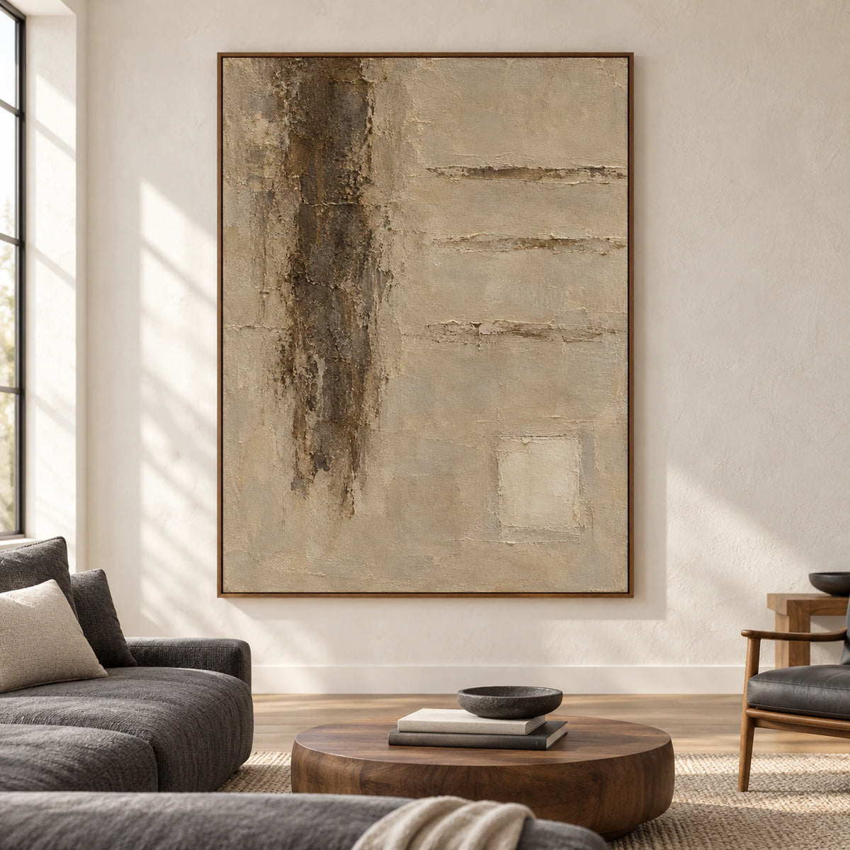 Front-facing vertical textured abstract painting on a pale plaster wall in a bright, spacious living room with charcoal and natural wood furnishings.