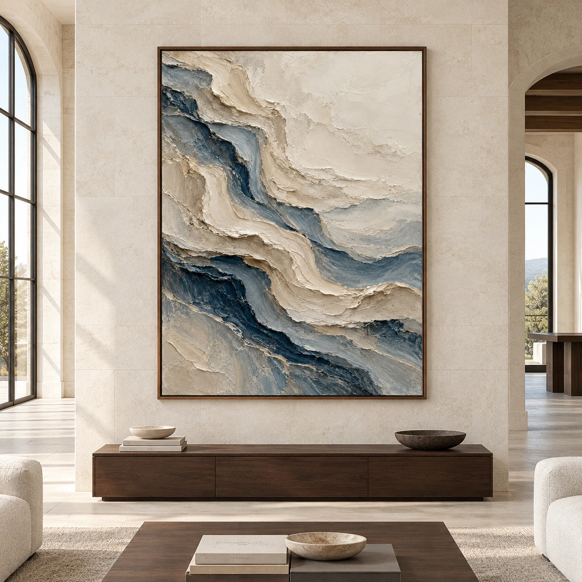 Straight-on view of a large vertical ivory and blue-gray painting on a pale limestone wall in a spacious daylit room with restrained dark timber furniture.
