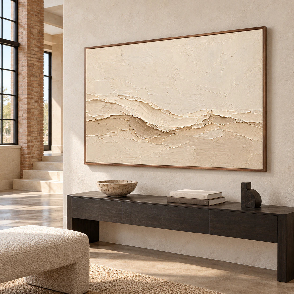 Large warm ivory abstract painting in a bright foyer with pale limestone architecture, tall windows and a dark console, viewed from the left at standing height.