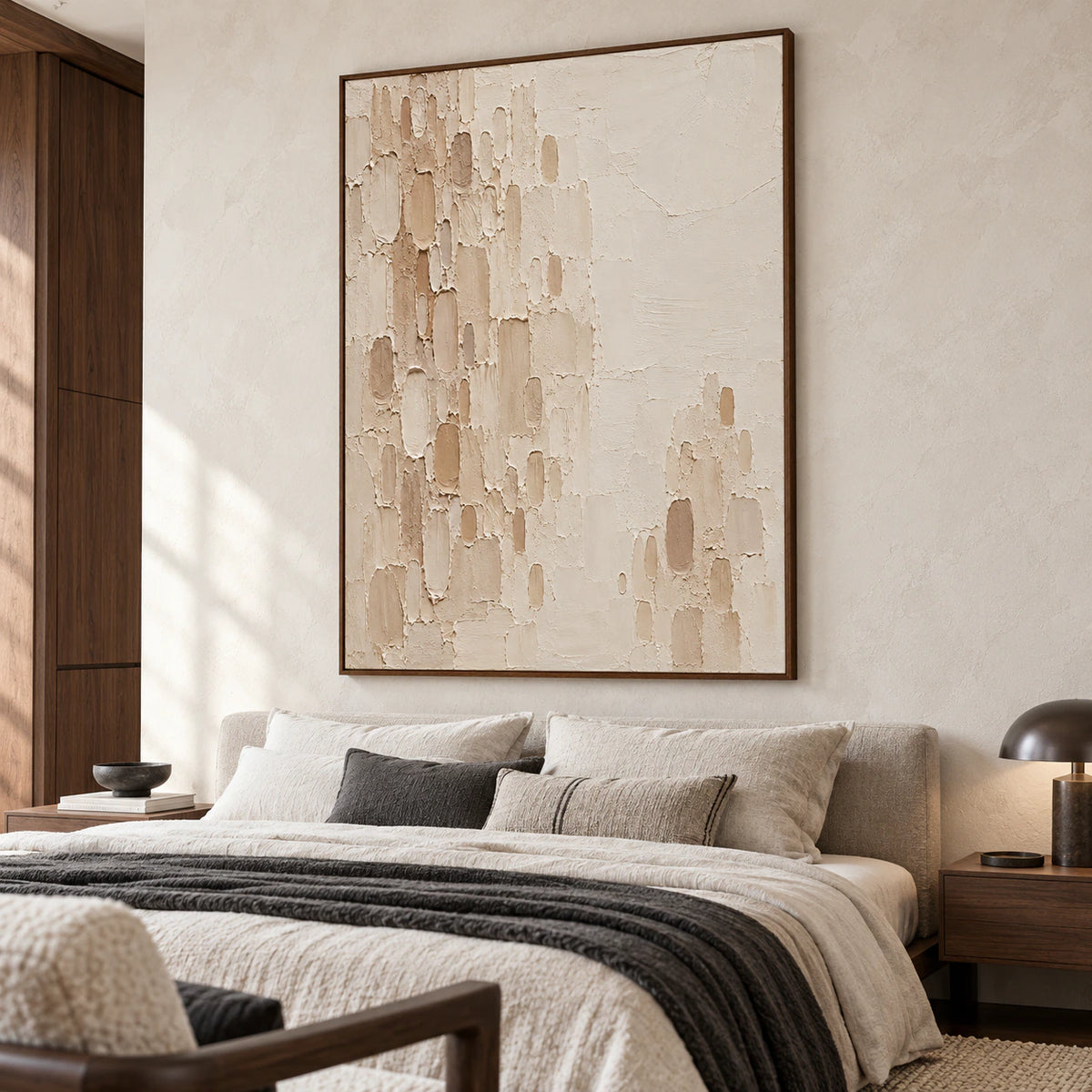 Large vertical Oatmeal-Recess painting above a low bed with pale linen, muted charcoal accents and dark wood, viewed from the left near the foot of the bed.