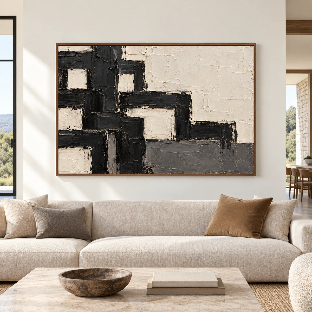 Large ivory and charcoal abstract painting viewed straight on in a bright, spacious modern living room with cool stone and muted wood furnishings.