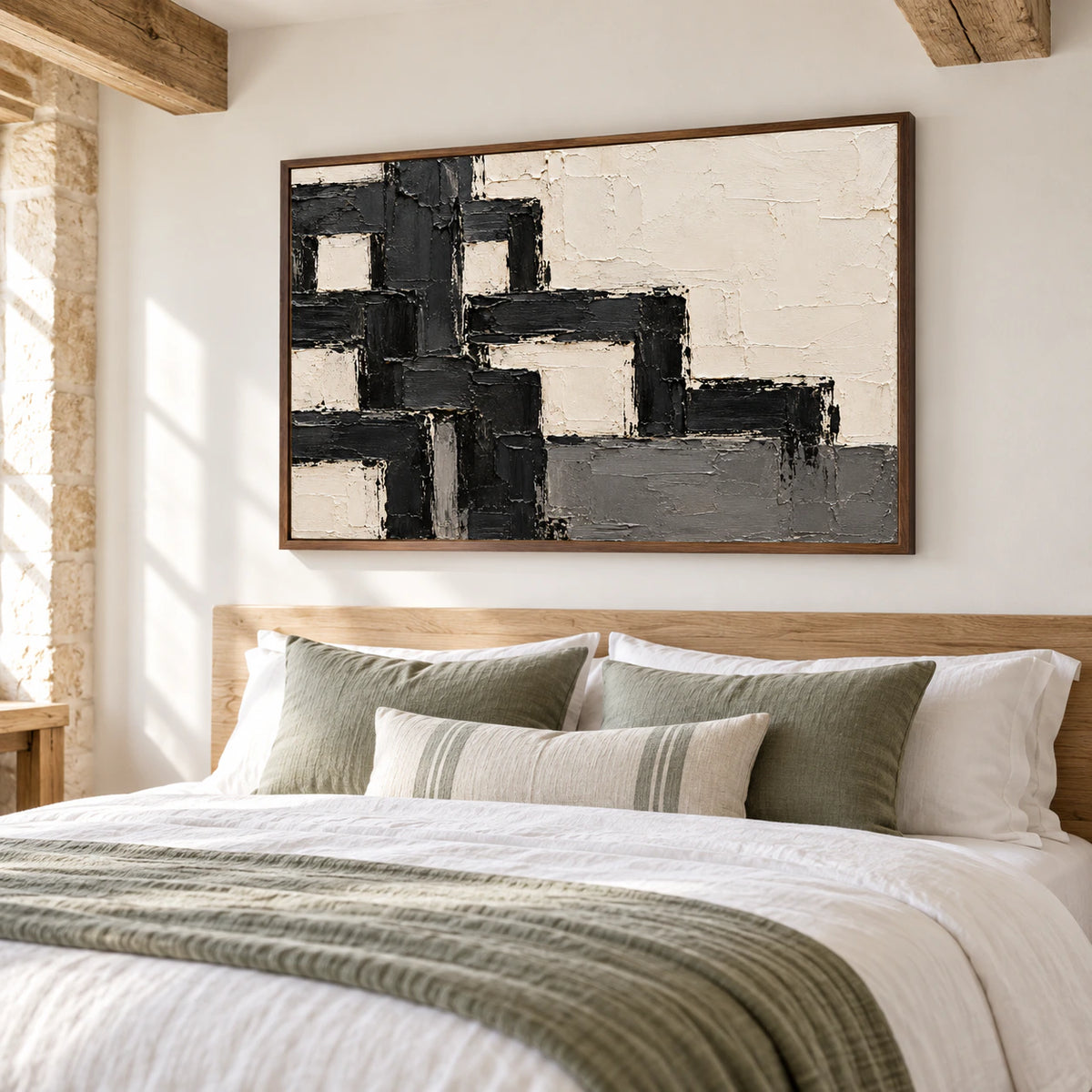 Ivory and charcoal abstract painting above a light oak headboard, viewed from a low left angle across a bed with white linen and muted sage accents.