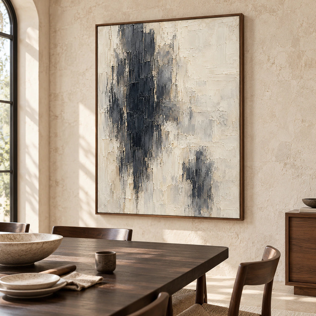 Obsidian-Pillars on a light limestone wall above a long dark wood dining table with slim chairs, viewed from a slight left angle in side daylight.